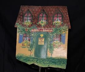 Maison jaune à volets bleus, fleurs aux fenêtres