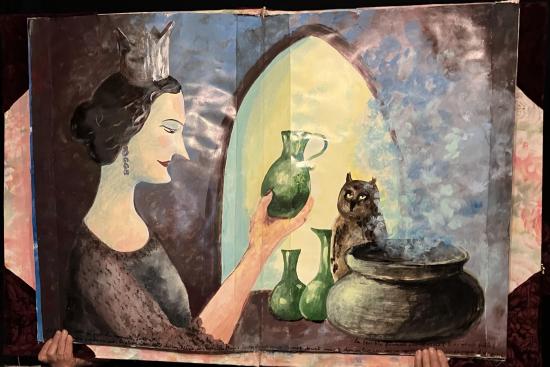 La reine contemple un flacon, de la vapeur s'échappe d'un pot, un hibou trône sur la table