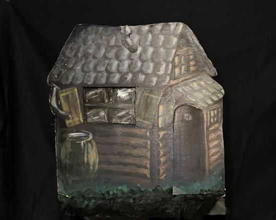 Cabane en rondins gris-bruns, avec un tonneau posé devant