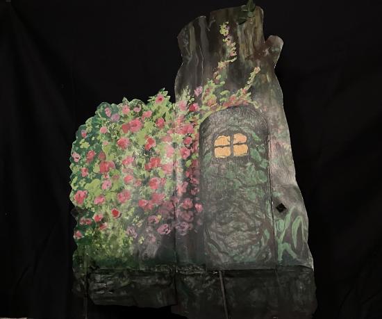 Rosier sauvage à côté un tronc d'arbre, une porte s'ouvre dans le tronc