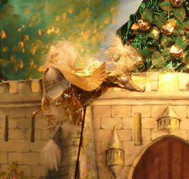 Oiseau doré devant des pommes d'or et une enceinte de château