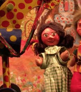 Fillette brune vêtue d'une robe à carreaux verts et blancs