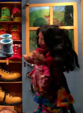 Cliente du bottier, femme aux cheveux noirs devant un étal de chaussures