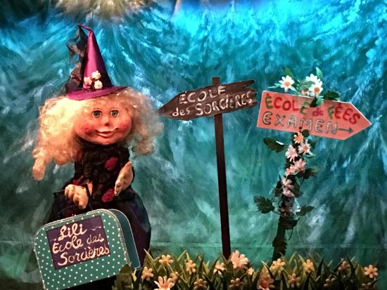 Lili-sorcière devant les panneaux indicateurs Ecole des sorcières et Ecole des fées