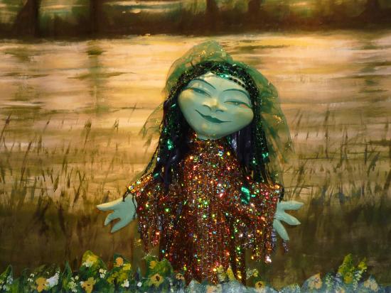 Ondine vêtue d'un habit doré dans un étang