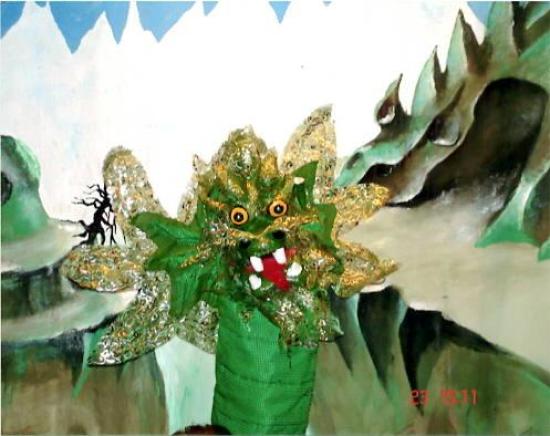 Dragon d'or devant un précipices, hautes montagnes à l'horizon