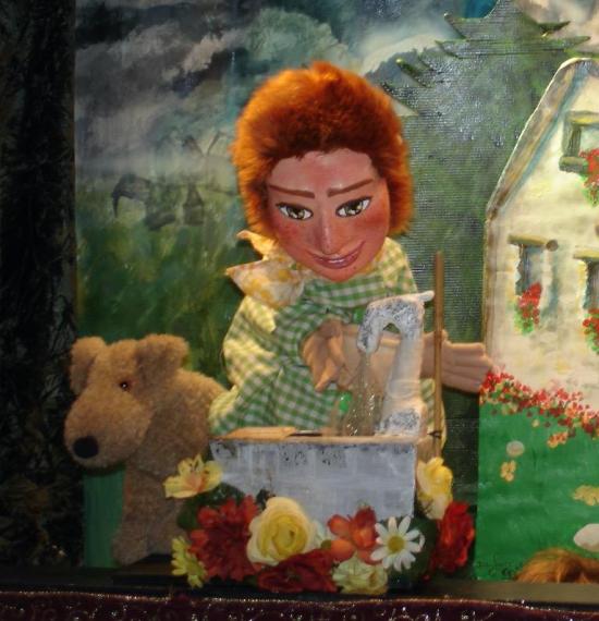 Jeune homme roux, vêtu d'une veste à petits carreaux verts et blancs, accompagné d'un chien, à côté d'une fontaine fleurie