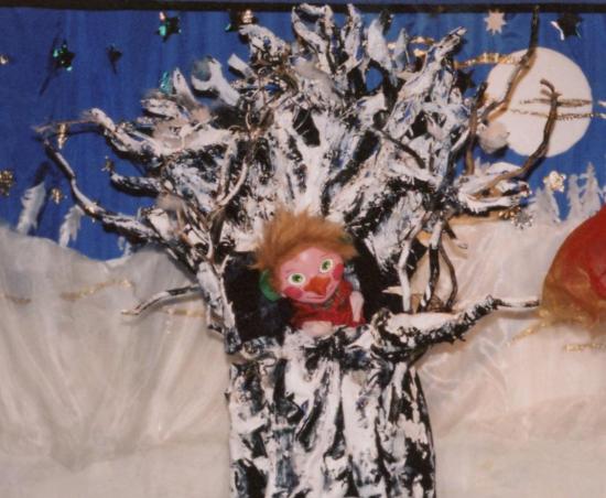 Pomme le lutin au nez en carotte et aux oreilles en feuilles de chou dans son arbre