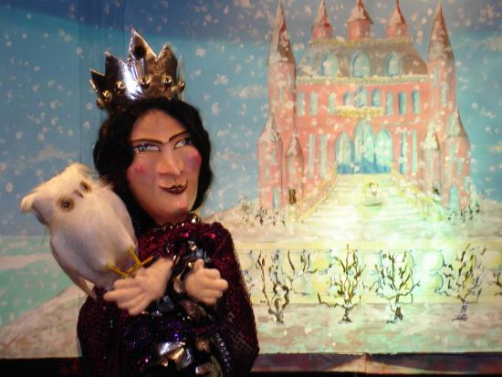 Reine de la Colline au rose devant un château rose et un parc enneigé