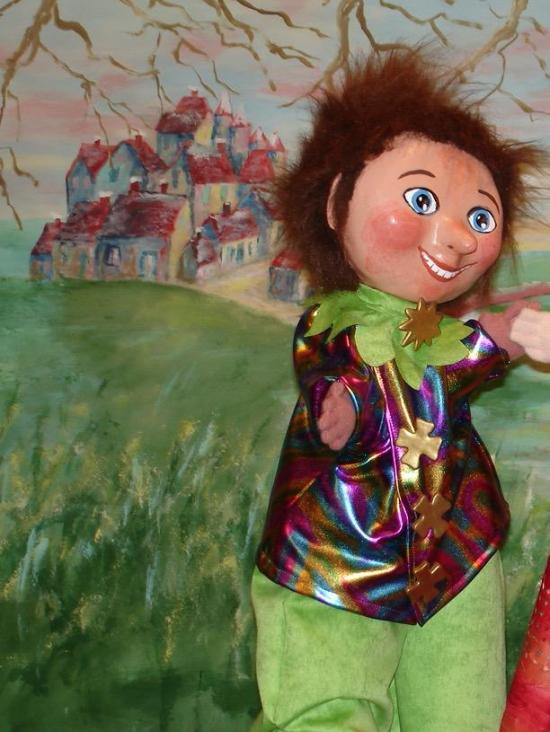 Garçon brun aux yeux bleus vêtu d'un pantalon vert tilleul et d'une veste de diverses couleurs