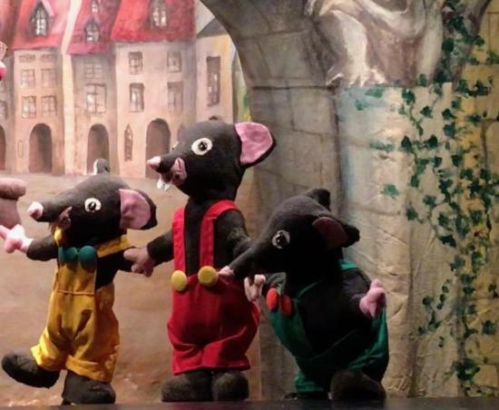 Trois souris grises vêtues de salopettes jaune, rouge et verte