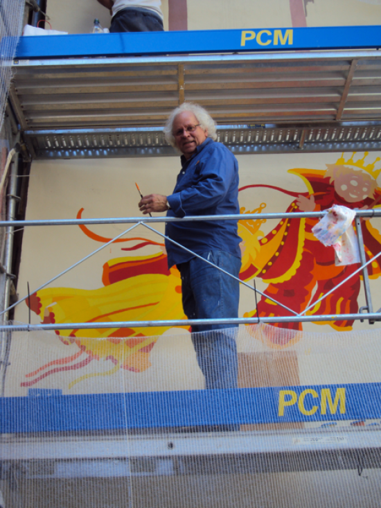 Wilfried Plaar sur un échafaudage, devant la fresque en cours de réalisation