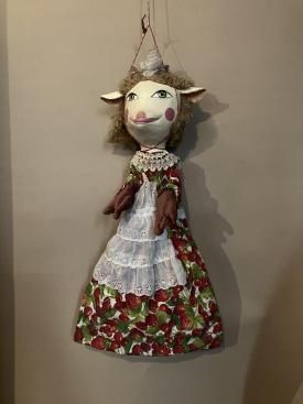 Chevrettes aux yeux verts, vêtue d'une robe avec des motifs de fruits et un tablier blanc