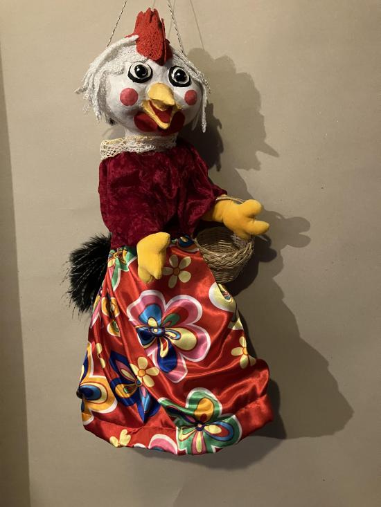 Poule vêtue d'une robe rouge à fleur et d'une blouse rouge foncé