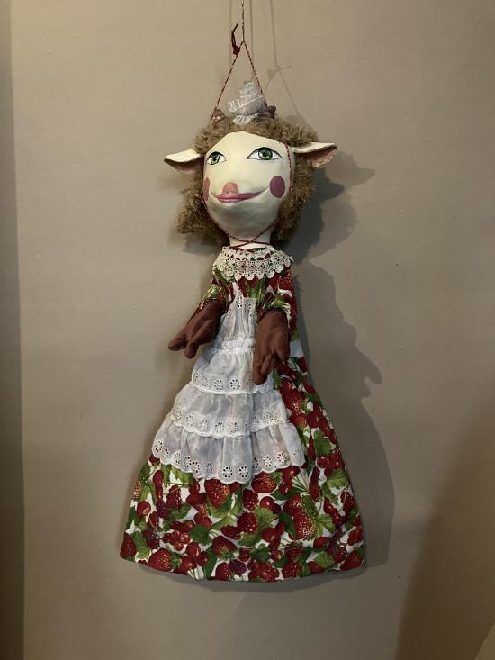 Chevrettes aux yeux verts, vêtue d'une robe avec des motifs de fruits et un tablier blanc