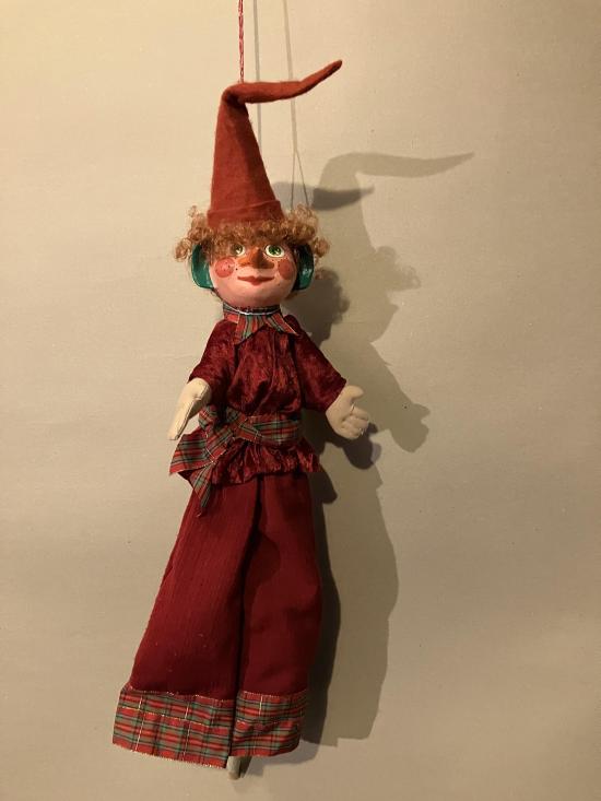 Lutin vêtu d'un pantalon et d'une veste rouges, coiffé d'un bonnet rouge