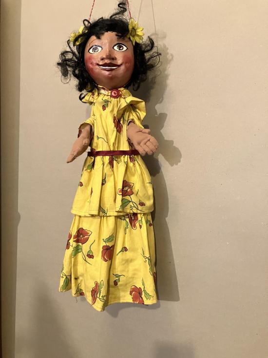 Jeune fille brune aux yeux bruns vêtue d'une robe jaune à fleurs