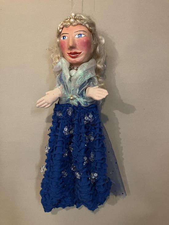 Jeune fille blonde aux yeux bleus, vêtue d'une robe bleue et d'un châle transparent