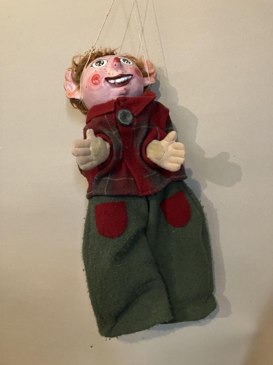 Jeune homme roux vêtu d'un pantalon gris et d'une veste à carreaux rouge