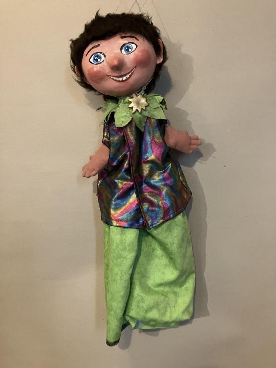 Garçon brun aux yeux bleus vêtu d'un pantalon vert tilleul et d'une veste de diverses couleurs