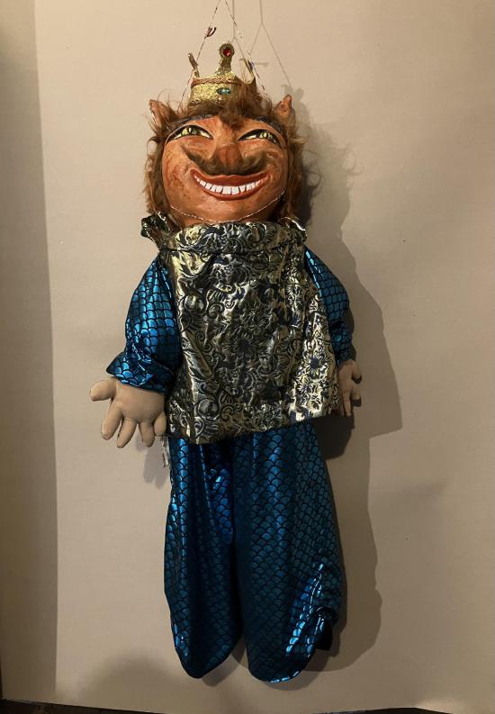 Tigre coiffé d'une couronne d'or, vêtu d'une tunique bleue et d'une cape argentée; il sourit