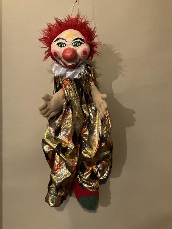 Clown à gros nez rouge et yeux bleus, vêtu d'un costume d'arlequin