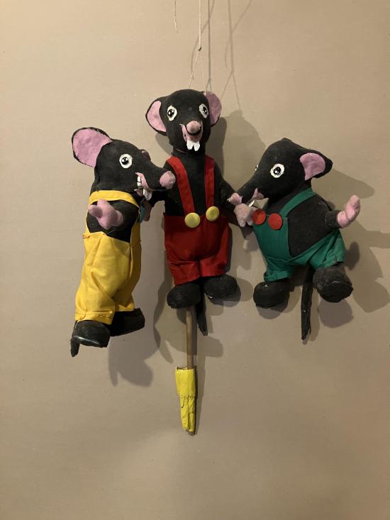 Trois souris grises vêtues de salopettes jaune, rouge et verte