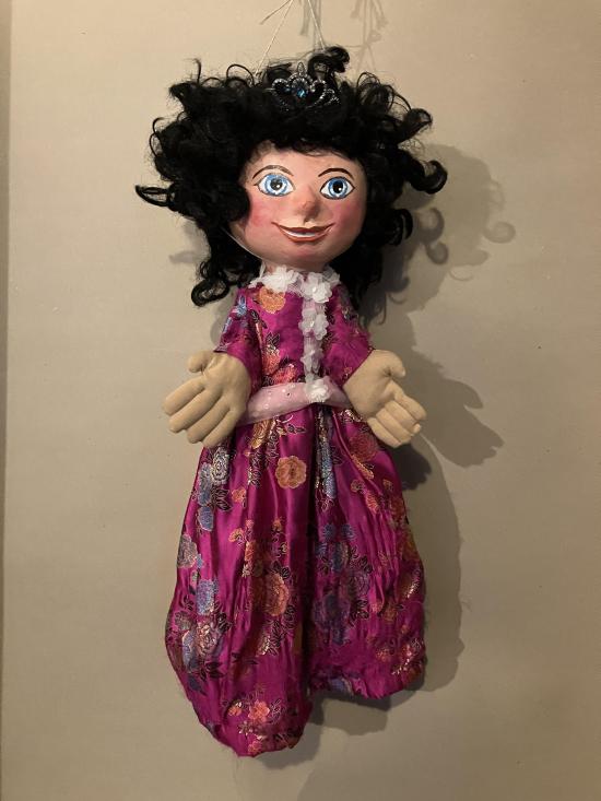 Jeune fille noiraude aux yeux bleus, vêtues d'un costume mauve à fleurs