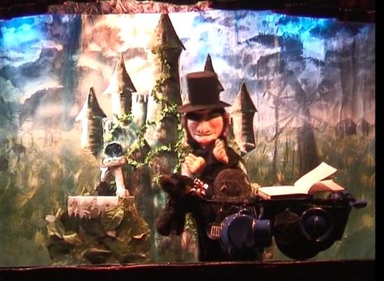 Taragoun Gossalan, le magicien vêtu de noir et coiffé d'un haut-de-forme noir devant le château abandonnée des fées