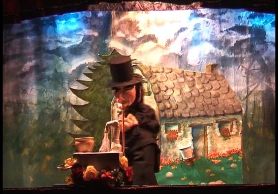 Taragoun cherche le trésor dans la fontaine, une jolie maison fleurie en arrière-plan