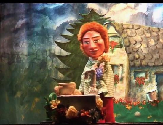 Jeannot, à côté de la fontaine, tient dans ses mains la pierre bleue qui était dans un panier