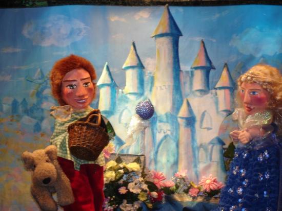 Jeannot et Fée Bellazure à côté de la fontaine surmontée de la pierre bleue, devant le château blanc