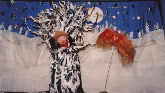 Pomme le lutin sort la tête de son arbre et parle avec un oiseau rouge