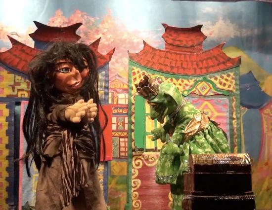 Perle d'Or et Fleurétoile en grande grenouille devant des maisons colorées