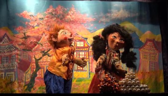 Lilou et Youki sur la place du village, maisons colorées et cerisier en fleurs roses