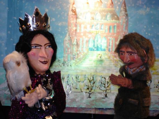 La reine de la Colline aux roses avec son jardinier devant le château rose et le jardin couverts de neige