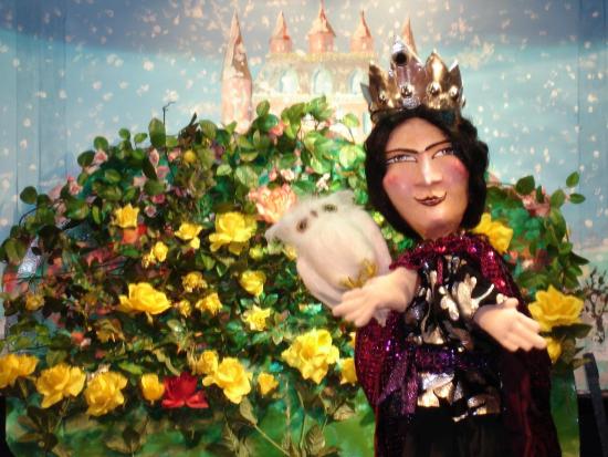 La reine de la Colline aux roses avec son hibou devant son château et un rosier géant