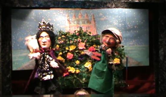 La reine et le jardinier devant un immense rosier, château rose en arrière-plan