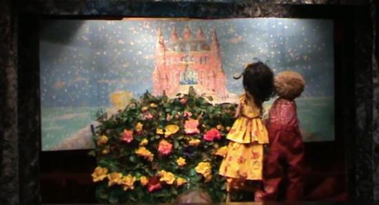 Deux enfants devant un rosier, jardin et château enneigés en arrière-plan