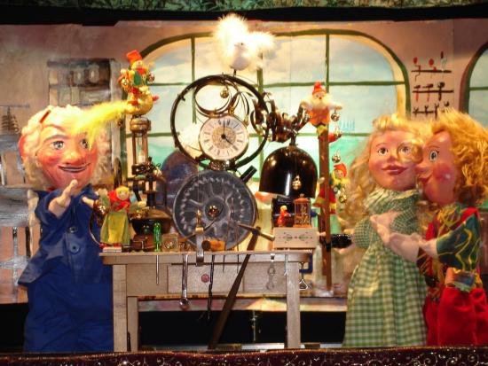 Monsieur Léon à côté de sa machine à fabriquer des boîtes à musique, deux enfants le regardent