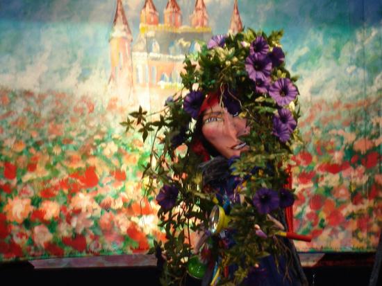 Reine déguisée en gitane emprisonnée par les fleurs, roseraie en fleurs, château rose en arrière-fond