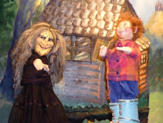 Théo bébé avec ses bottines bleues et la mère de Croc'Peton devant la cabane de ce dernier