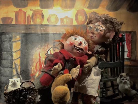 Tom sur les genoux Tatie Berthe, dans une grande cuisine avec une cheminée allumée