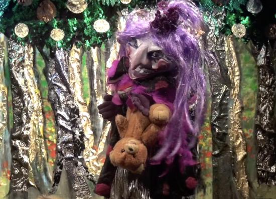 La sorcière Kroc Mauve devant la forêt aux fruits d'or; elle tient petit ours dans ses mains