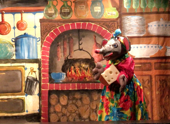 Fifi la Souris dans la cuisine, avec un morceau de fromage dans les mains