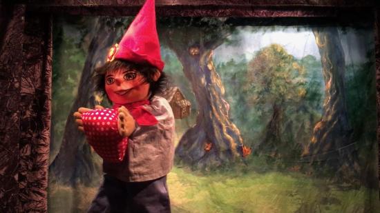 Léon, coiffé du chapeau de Titibert et tenant son repas dans les mains, dans la forêt