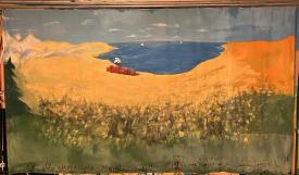 Étendue désertique et jaune, baie et montagne à l'horizon, citadelle rouge