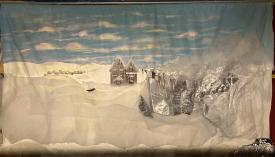 Collines enneigées sous un ciel bleu avec quelques nuages, maison au centre, village en arrière-plan