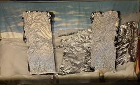 Collines enneigées sous un ciel bleu avec quelques nuages, rochers d'argent sur la droite et deux rochers d'argent verticaux