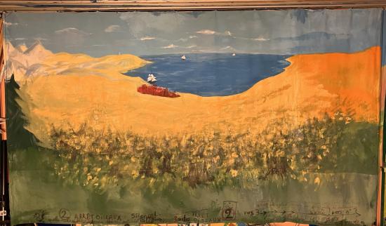 Étendue désertique et jaune, baie et montagne à l'horizon, citadelle rouge